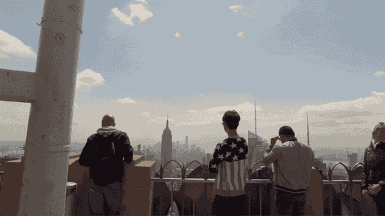 Travellers taking in the New York skyline from an observation deck.